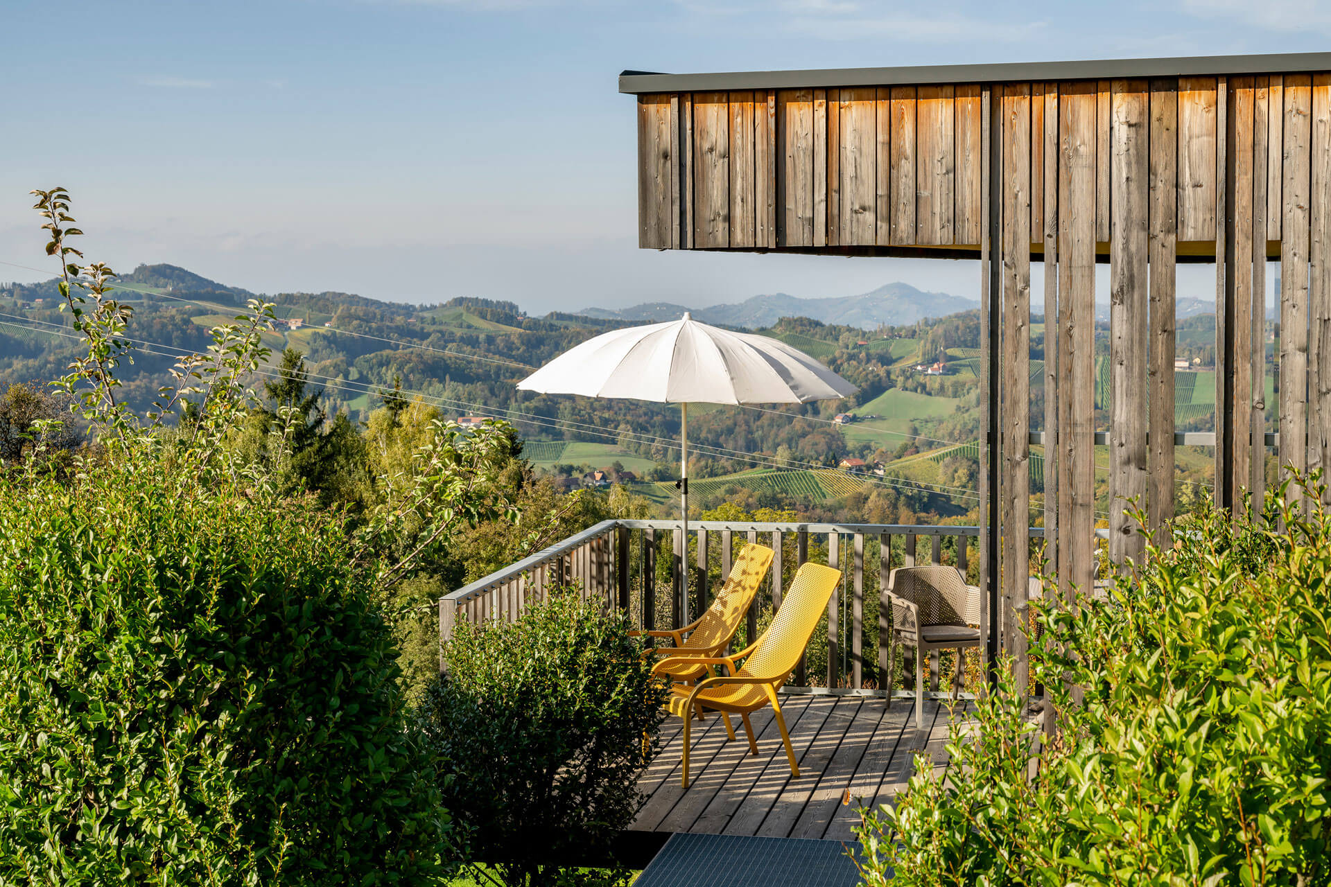 Thymianlodge Terrasse — private Außenfläche mit Liegen und weitem Blick über Weinberge und Hügel.