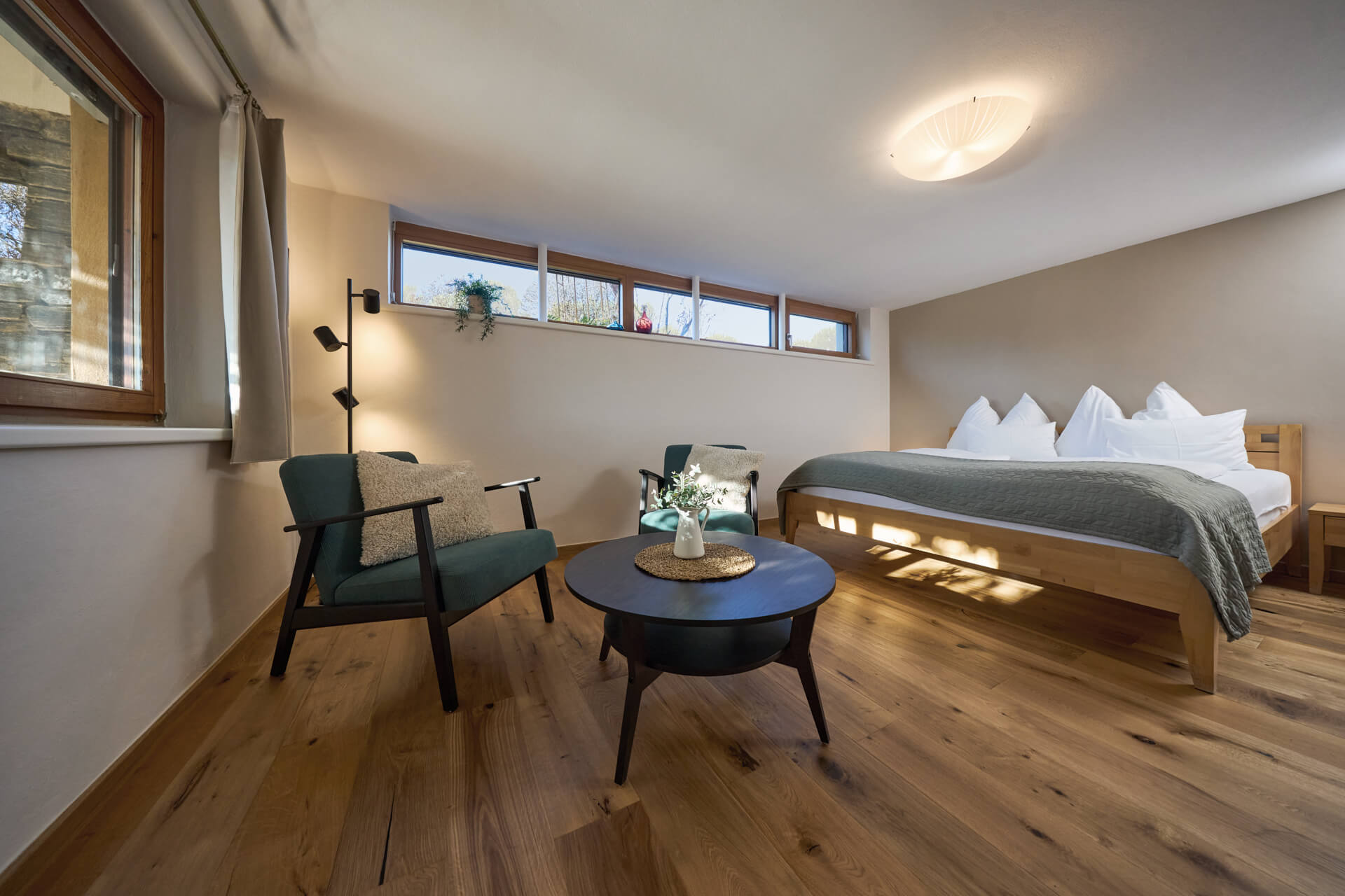 Marillen Lodge at Wurzenberg — großzügiger Wohn- und Schlafbereich mit Holz, Licht und Blick ins Grüne.