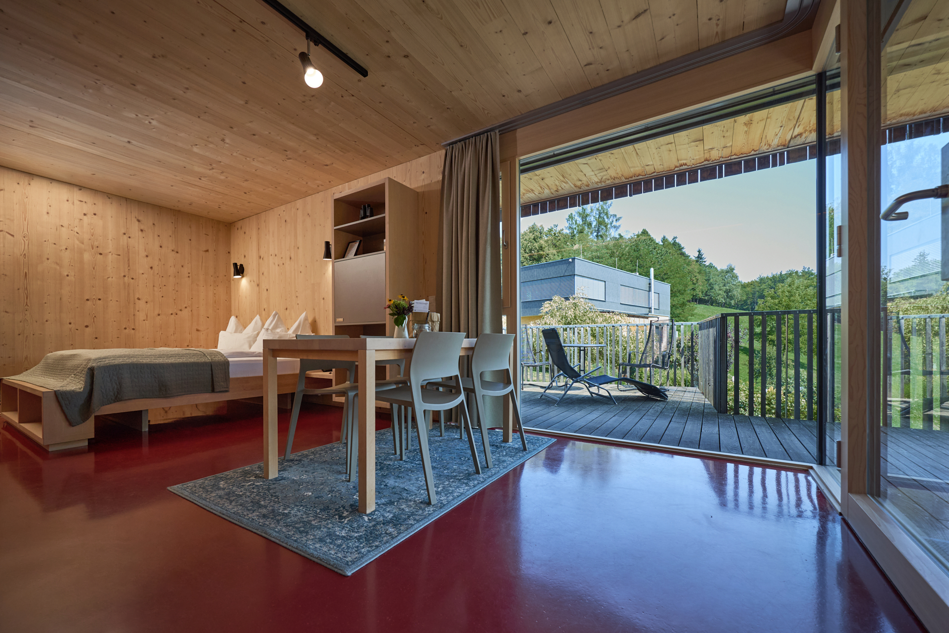 Innenraum einer Lodge am Wurzenberg, mit Holzarchitektur und Terrasse mit Ausblick.