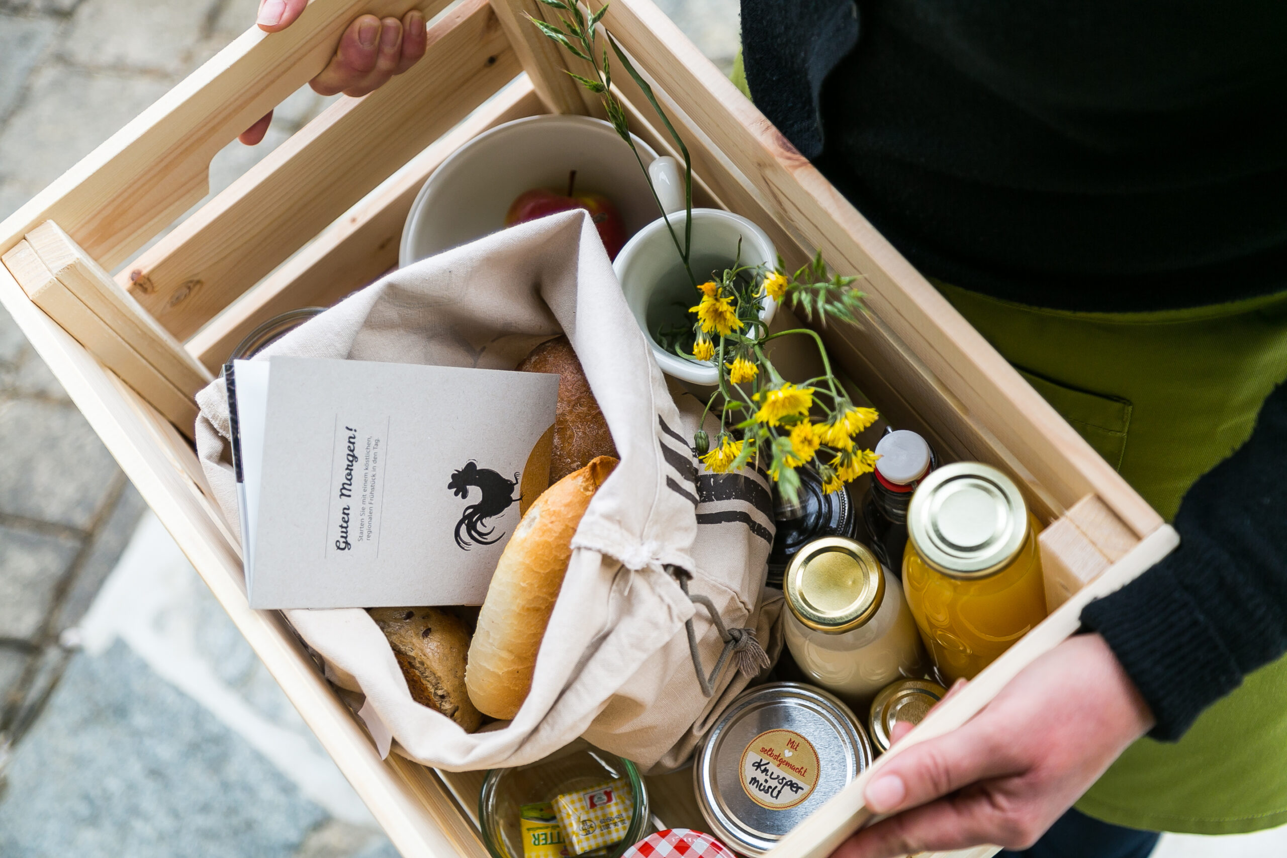 Frühstückskorb mit regionalen Produkten wird in eine Lodge am Wurzenberg serviert.