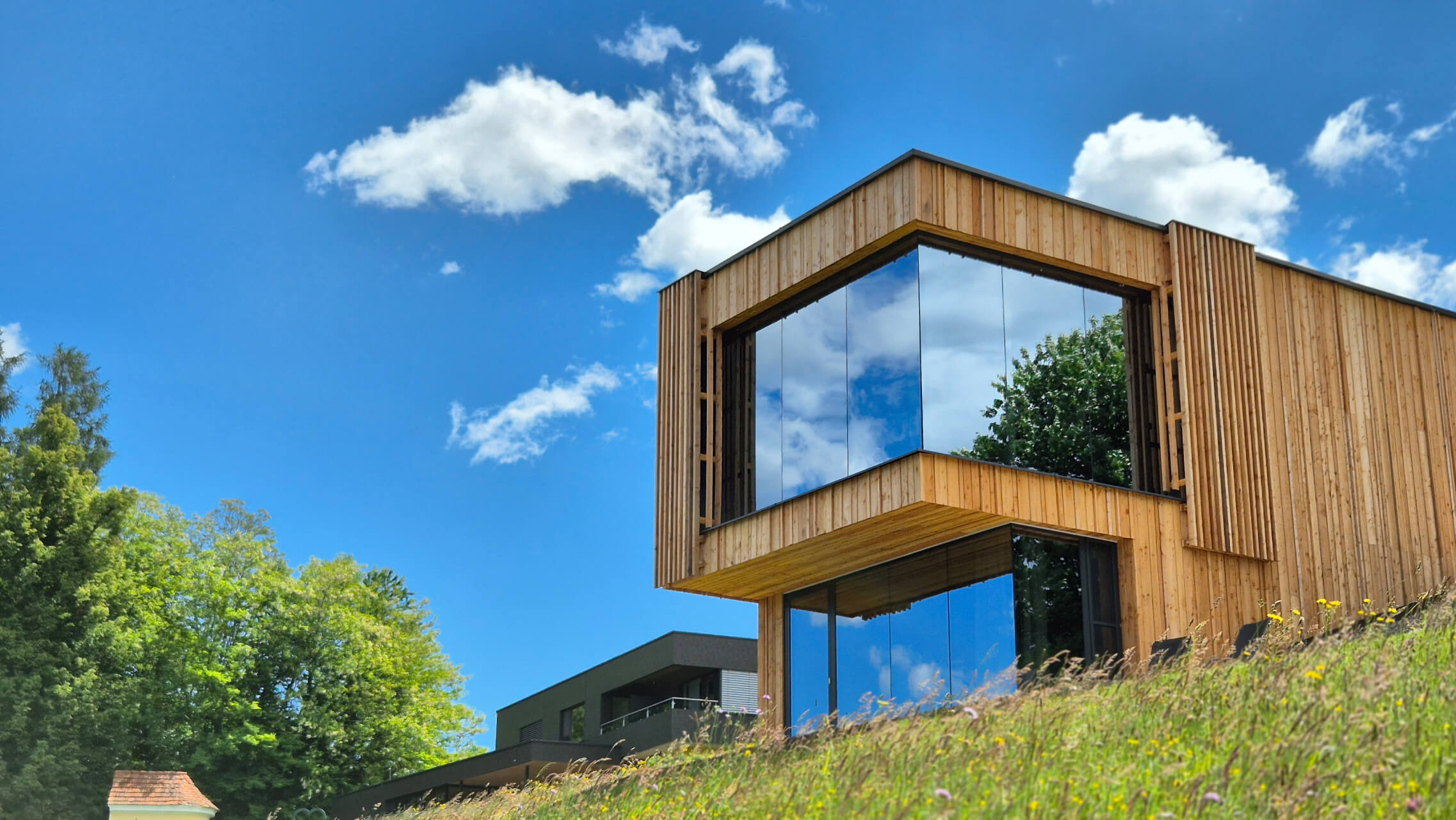 Rosenlodge am Wurzenberg — Freistehendes Haus mit Panoramafenstern und Blick über Hügel und Weinreben.